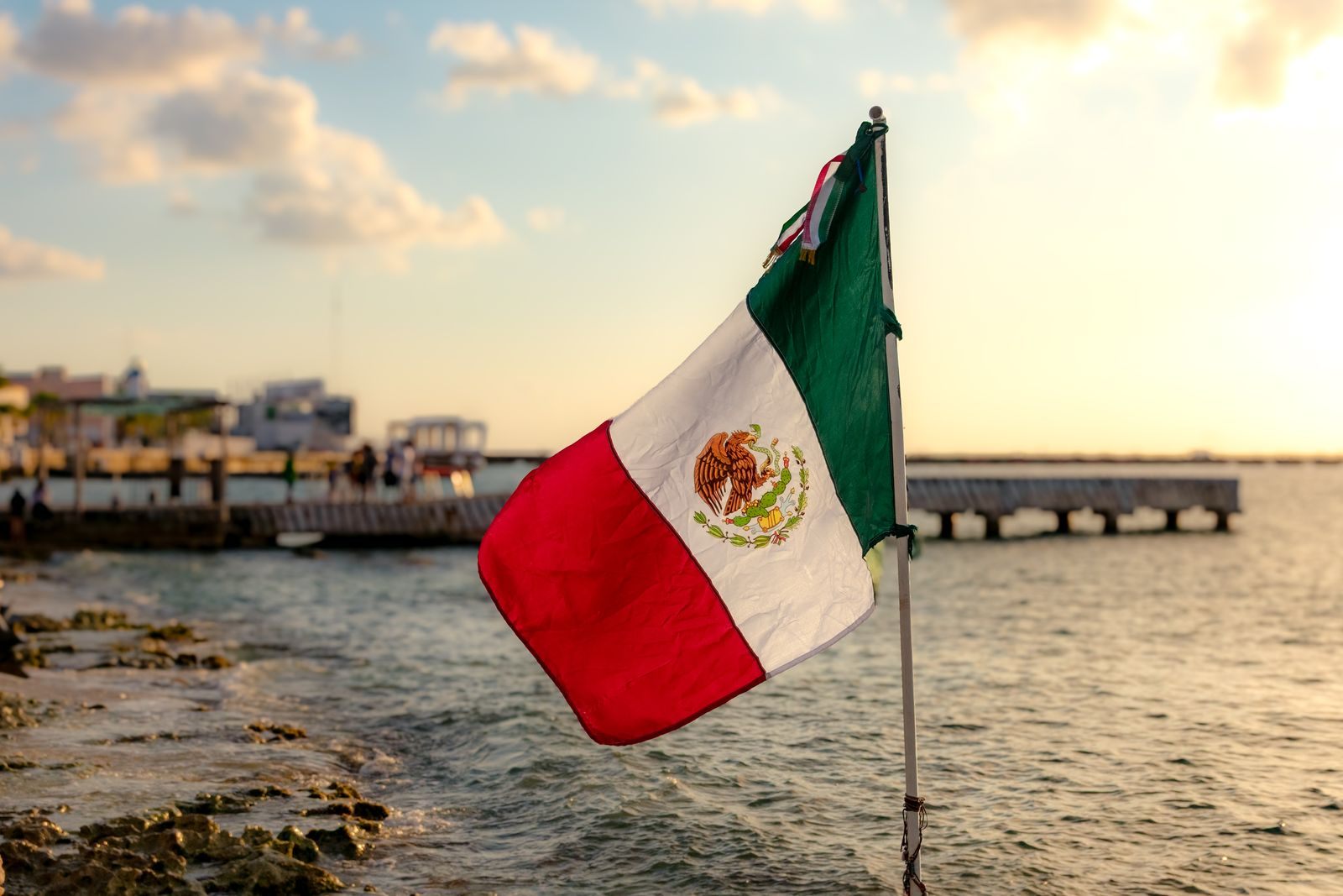 Mexican flag flying beside a pier on the Caribbean coast of Mexico