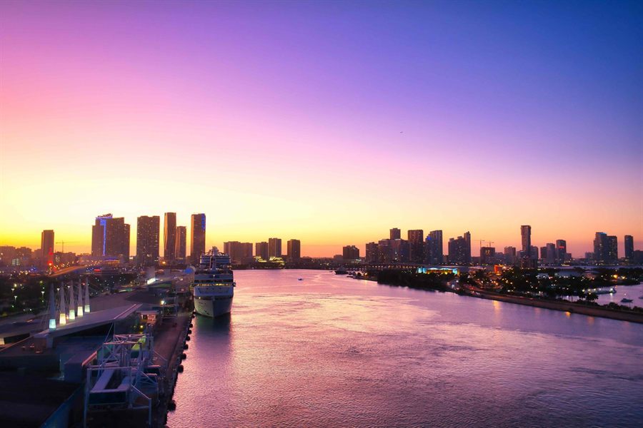 Cruise ship in the Miami channel at dusk below the city skyline
